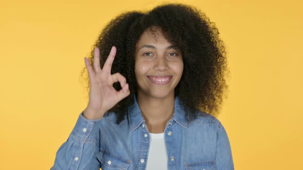 African Woman with OK Sign, Yellow Background 