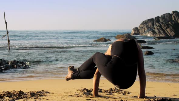 Girl in Black Tracksuit Meditates in Yoga Eight Angle Pose