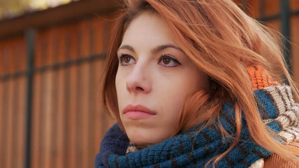 Pensive attractive young red hair woman thinking alone-outdoor