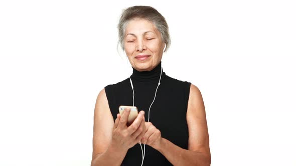 Picture of Senior Beautiful Grandmother Looking at Mobile Phone Typing Listening Favourite Music