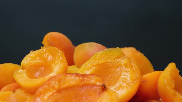 Seedless Apricots Spin in a Circle on a Black Background