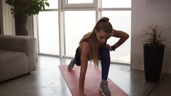 Young Fit Female in Sportswear Doing Stretching Lunge Exercise Indoor Home Interior
