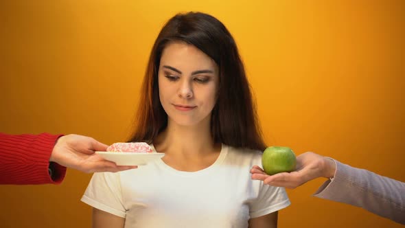 Beautiful Girl Eating Donut Instead of Apple, Sugar Addiction, Unhealthy Snack