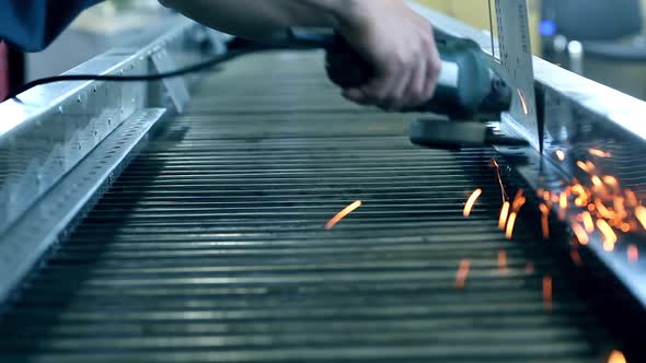 Sparks From an Industrial Grinder Fall and Bounce on the Ground of a Workshop