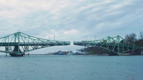 Oskara Kalpaka swing bridge closing in Liepaja in cloudy autumn day, wide shot