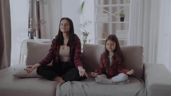 Calm Smiling Mother with Cute Little Daughter Doing Yoga Exercise at Home Pretty Girl and Attractive