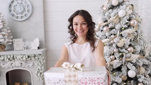 Attractive Brunette with Christmas Gifts on a Background of a Beautiful Interior. Christmas House