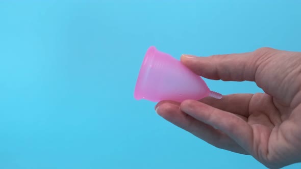 Pink Menstrual Cup Closeup on a Blue Background