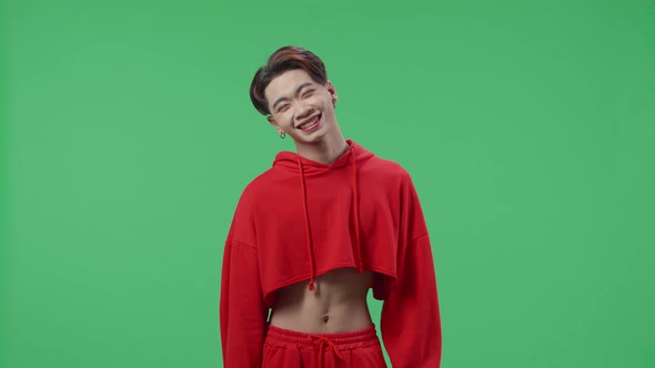 Jealous Young Asian Transgender Male Smiling While Standing In The Green Screen Studio