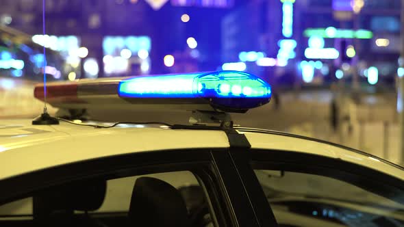 Flashing Flasher on the Roof of a Police Car at Night. Blinker.