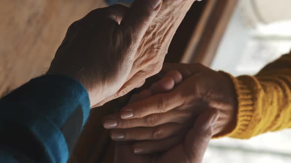 Vertical Video Aged Elderly Married Couple Holding Their Wrinkled Hands Against the Window During