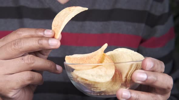 Holding a Bowl of Tasty Potato Chips Close Up