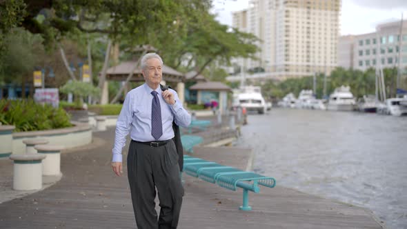 Businessman Walking By The River After Work