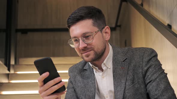 Smart Man Searching Information Online Texting Messages in Office Hall