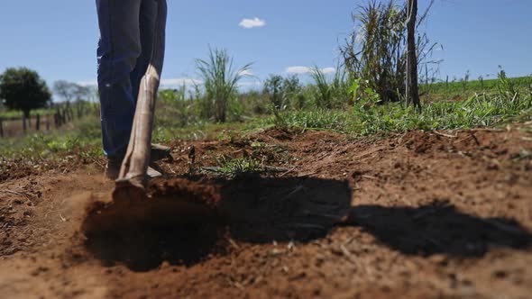 Brazilian farmer uses a hoe to till the dry dirt of a crop field during a major drought in Brazil. C