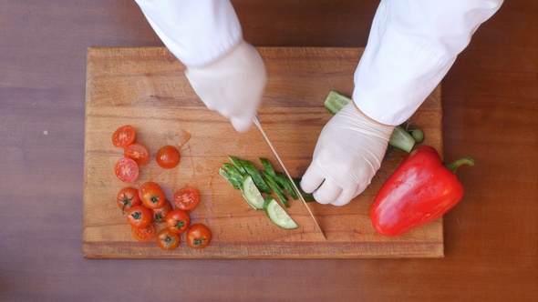 Cutting cucumber on a wooden board