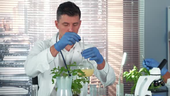 In a Chemistry Laboratory Research Scientist Mixing Two Compounds in Flask Using Pipette