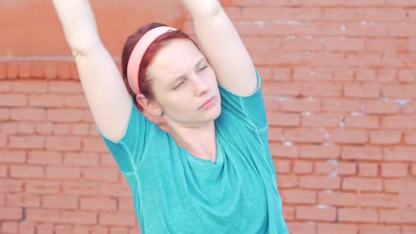 A young woman stretching before working out in urban environment.