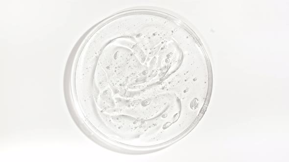 Transparent Cosmetic Gel Fluid with Bubbles in a Glass Bowl of Petri