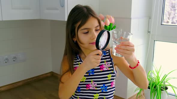 The Child Examines the Water with a Magnifying Glass