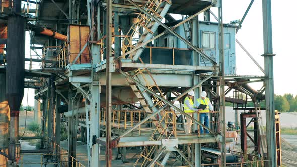 Massive Industrial Construction with Two Engineers Standing in It