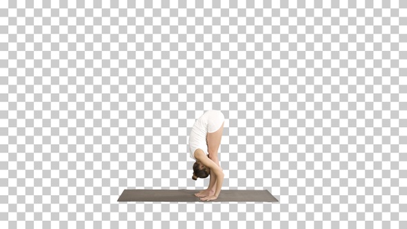 Beautiful model doing yoga exercise standing in Uttanasana with