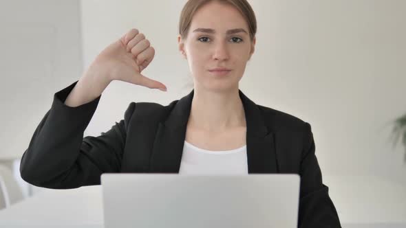 Thumbs Down By Young Businesswoman in Office