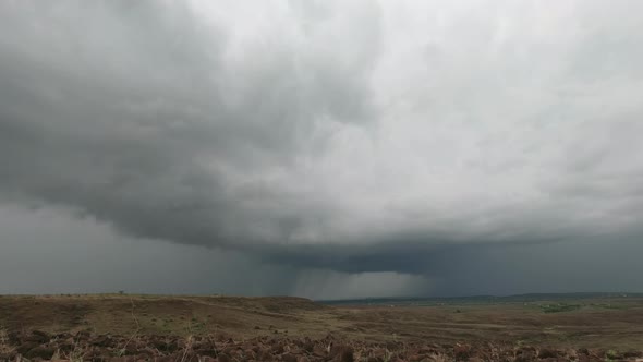 Gathering of a  Huge Storm clouds in the  sky over the parched Grassland rocky landscape during the
