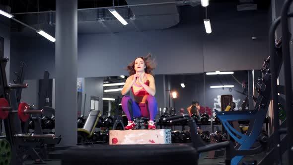 Young athletic woman doing box jump workout at gym. Healthy lifestyle.