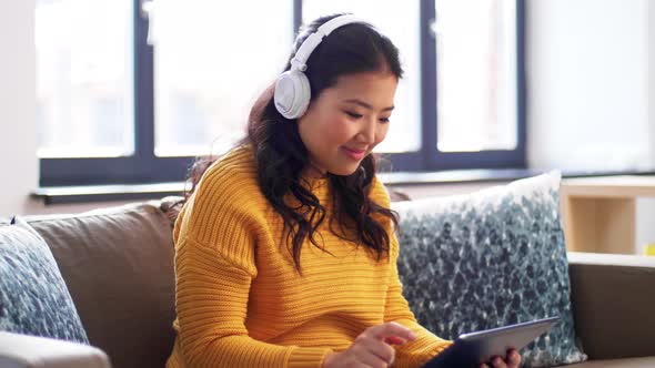 Happy Asian Woman in Headphones Listening To Music