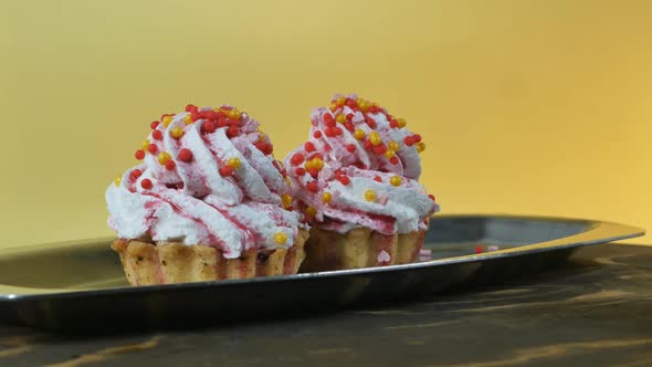 Closeup Two Cream Cakes Basket Decorated with Round Colored Balls in a Steel Tray Revolve on a