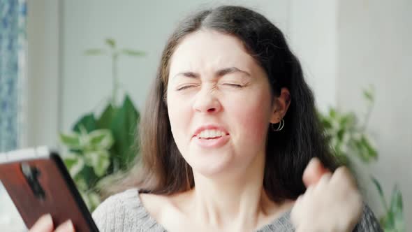 Portrait of Amazed Woman Bulging Eyes Using at a Smartphone