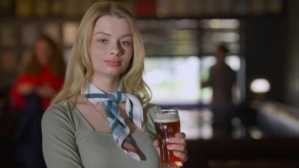 Confident Gorgeous Young Woman Posing with Beer Glass in Pub Indoors