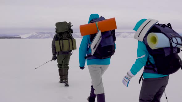 Four Young People Go Hiking in the Snowy Desert