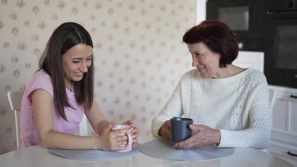 Mother and Daughter Talking and Drink Tea