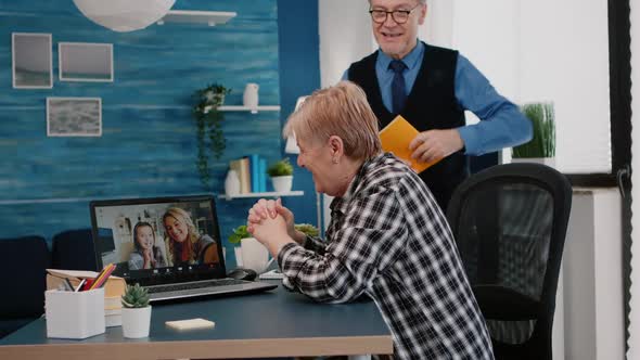 Excited Senior Woman and Her Husband Having Video Conference on Laptop