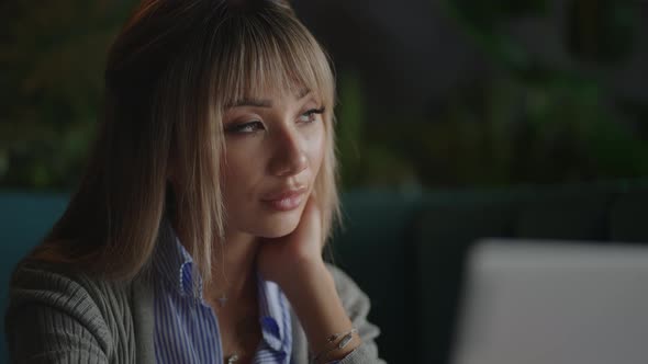 Portrait of a Beautiful Young and Attractive Asian Woman is Sitting and Looks Worried and Serious As