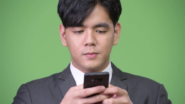 Young Handsome Asian Businessman Using Mobile Phone