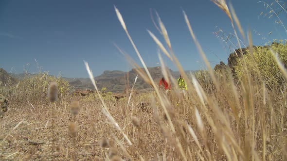 Hiking Couple Walking in Dry Grassland