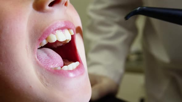 Dentist examining a young patient with dental tools