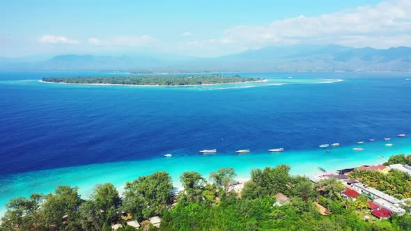 Vivid colors of blue azure sea stream between two tropical islands with lush vegetation and white sa