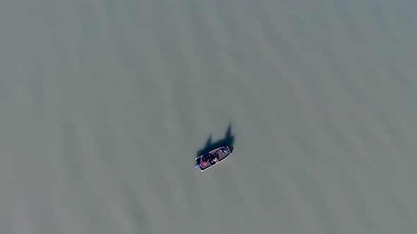 straight down shot of a boat on a vast lake with with two men casting for fish