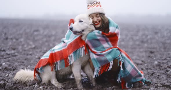 Woman with Her Dog on the Snowy Field