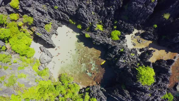 Aerial Drone View of Swimmers Inside a Tiny Hidden Tropical Lagoon Surrounded By Cliffs - Secret