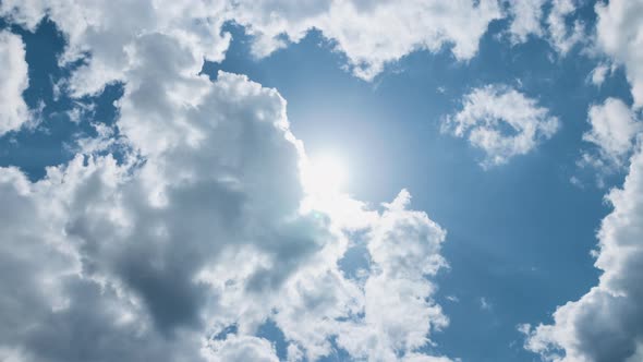 Low Angle Timelapse Bright Sun on Blue Summer Sky with Moving Fluffy Clouds Sun Shining Sunbeams
