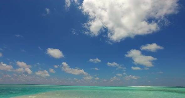 Natural overhead travel shot of a white paradise beach and turquoise sea background in vibrant 4K