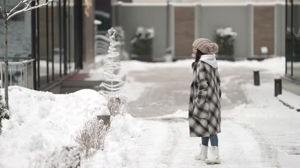 Female City Dweller Is Walking Outdoor at Winter Day Young Woman Dressed Coat and Hat