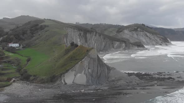 Aerial drone shot of a man over a cliff. Stunning nature landscape. Freedom feeling. Flysch, Zumaia.