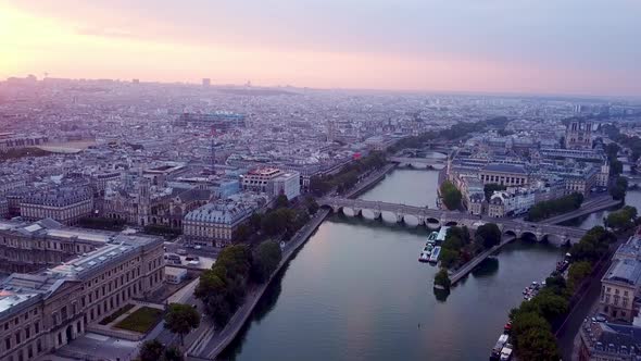 Flying over Seine river towards Ile de la Cite at sunrise. Panning view on Paris panorama. Pont Neuf