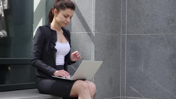 Woman with Headache Using Laptop Outside Office